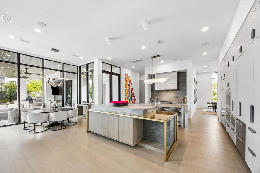 There are custom brass features on the kitchen island, in the walls of the bar and the primary bedroom, and in the floor of the study. This brass was also used to create a custom fireplace art piece. There are custom brass features on the kitchen island, in the walls of the bar and the primary bedroom, and in the floor of the study. This brass was also used to create a custom fireplace art piece.