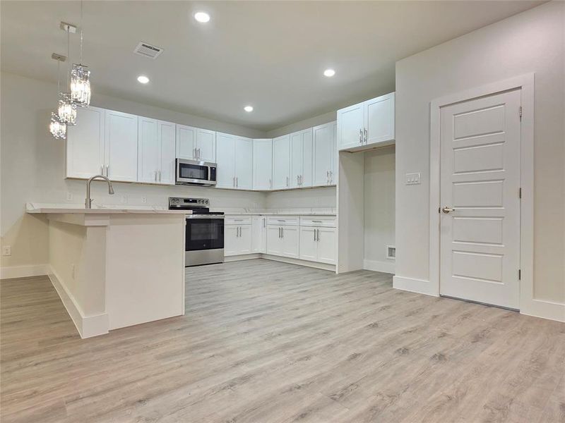 Picture of kitchen, pantry, designer chandleier lightning, white shaker cabinets self closing.