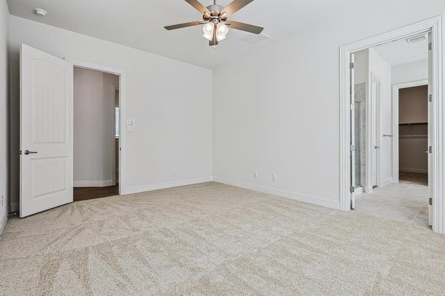 Carpeted empty room featuring ceiling fan