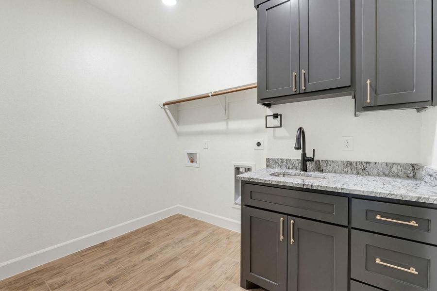Functional laundry space featuring durable wood-look tile flooring and practical storage solutions. Functional laundry space featuring durable wood-look tile flooring and practical storage solutions.