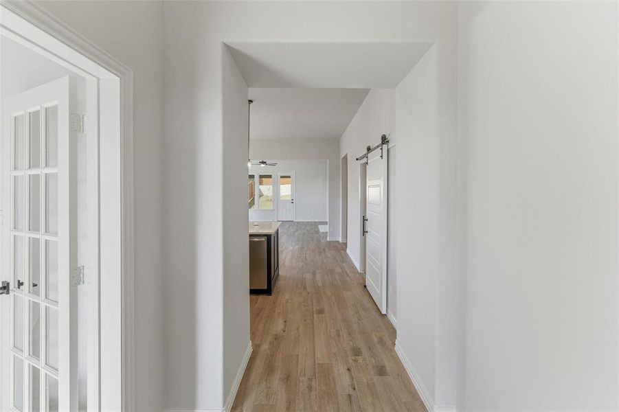 Hall featuring a barn door and light wood-type flooring