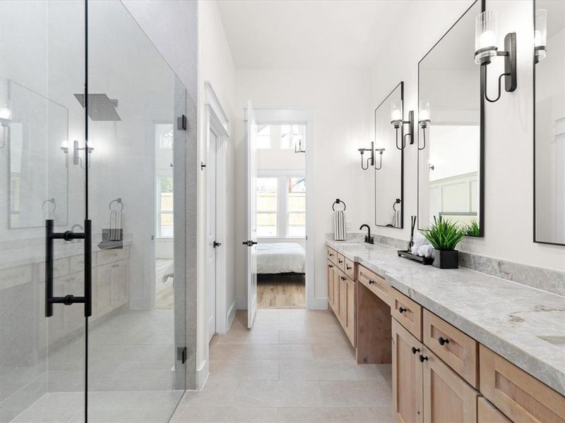 Ensuite bathroom featuring double vanity, a shower stall, and light tile patterned floors