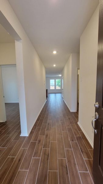 Corridor featuring wood-like tile and recessed lighting