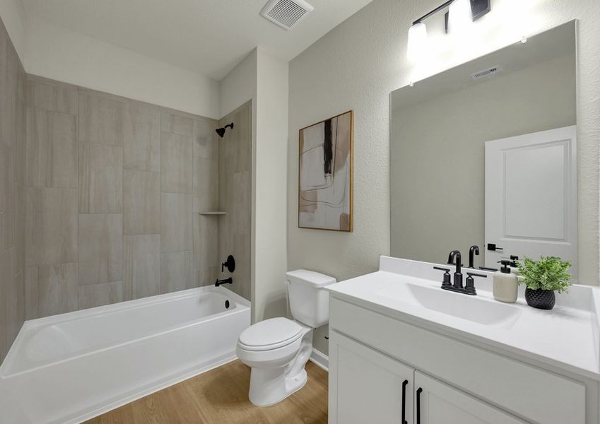 Secondary bathroom featuring a white vanity with cultured marble countertop and a tub/shower combination.