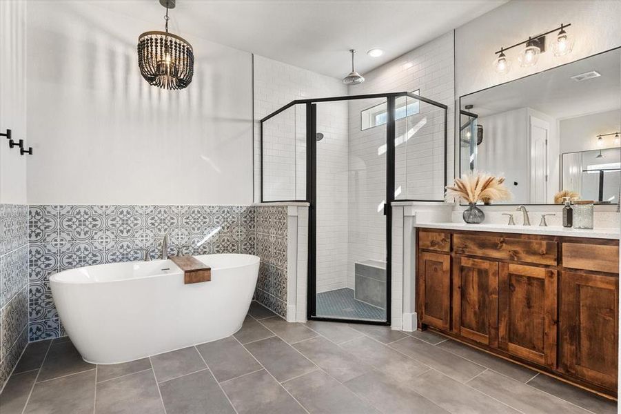 Bathroom with a soaking tub, tile walls, vanity, tile patterned floors, and a stall shower