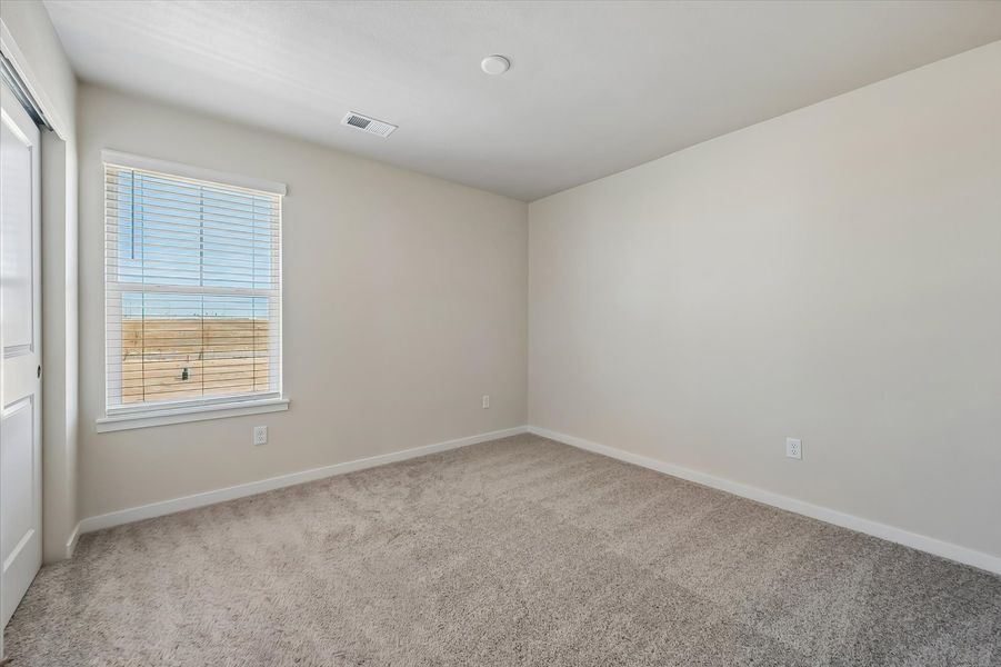 A room with a carpet and a window.