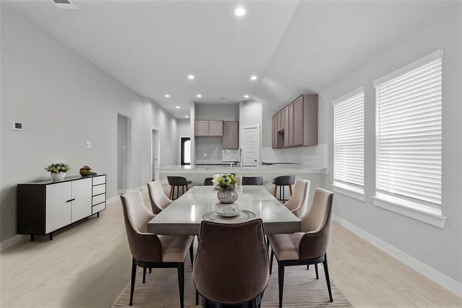 This lovely dining room is perfect for starting the day out on the right foot! This space showcases custom paint, high ceilings, recessed lighting, large windows adding to the ample natural light, and tile flooring!