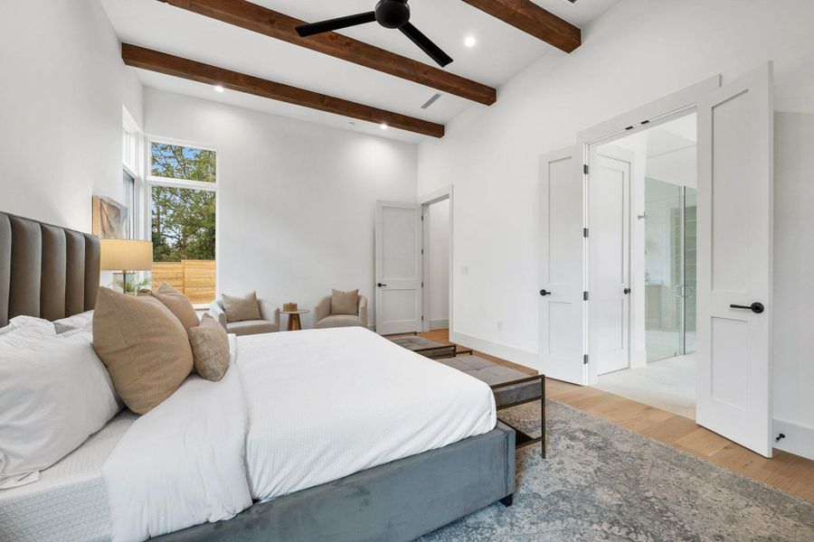 Bedroom featuring light wood-style floors, beam ceiling, and a ceiling fan Bedroom featuring light wood-style floors, beam ceiling, and a ceiling fan