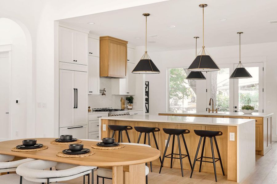 Kitchen featuring a spacious island, light countertops, light wood-type flooring, a kitchen breakfast bar, and white cabinets Kitchen featuring a spacious island, light countertops, light wood-type flooring, a kitchen breakfast bar, and white cabinets