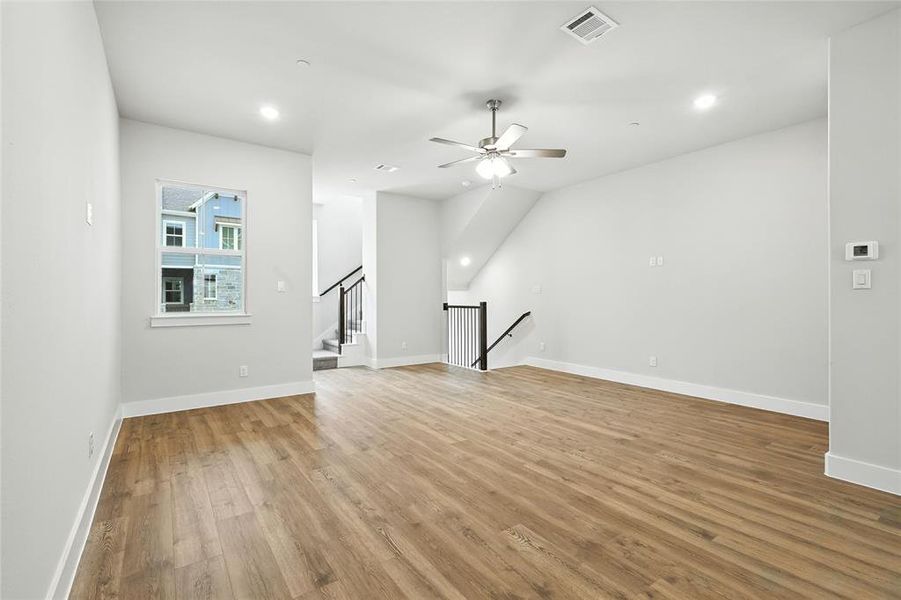 Unfurnished living room with light wood-type flooring, recessed lighting, stairway, and a ceiling fan