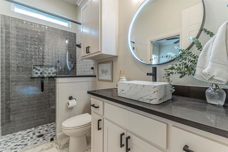 Full bathroom featuring vanity, a stall shower, and a textured wall Full bathroom featuring vanity, a stall shower, and a textured wall