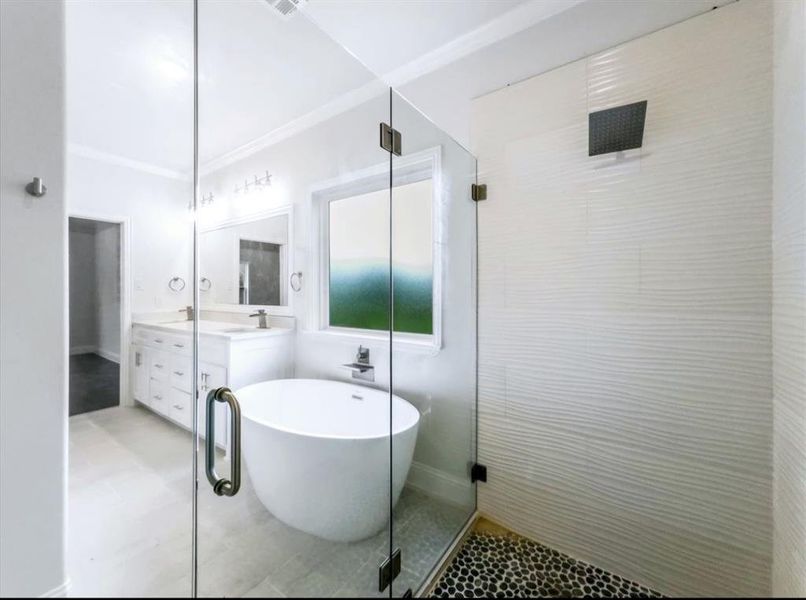 Full bath featuring ornamental molding, a freestanding bath, vanity, and a shower stall Full bath featuring ornamental molding, a freestanding bath, vanity, and a shower stall