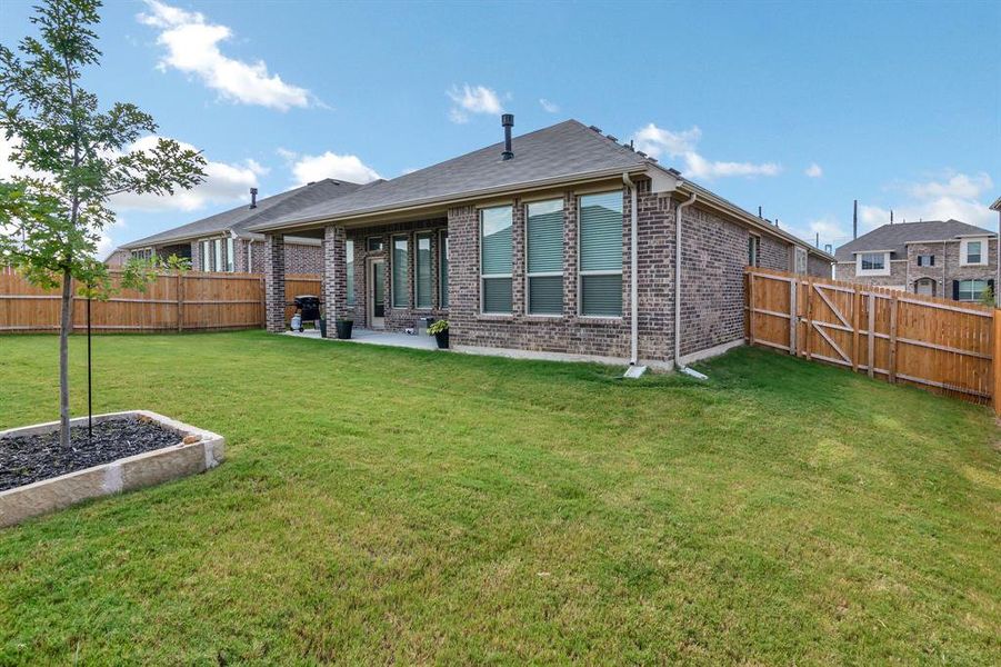 Back of property with brick siding, a patio, and a fenced backyard