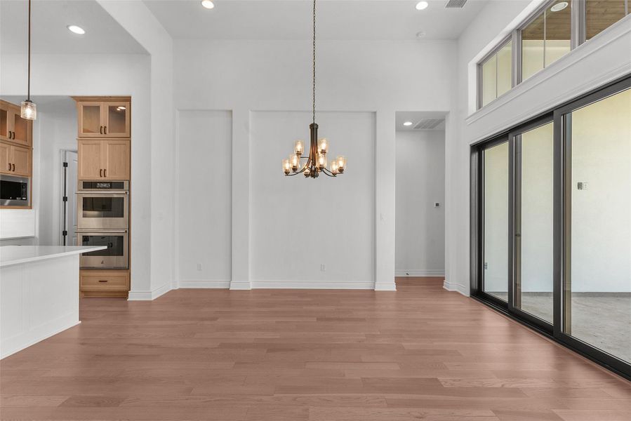 An open-concept living space with soaring ceilings and rich hardwood flooring, offering seamless indoor-outdoor flow.