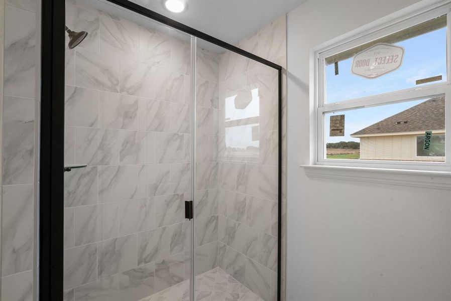 Bathroom featuring a shower with shower door Bathroom featuring a shower with shower door