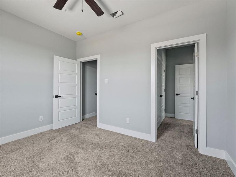 Unfurnished bedroom with carpet floors, baseboards, and ceiling fan