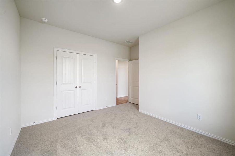 Unfurnished bedroom with carpet flooring and a closet