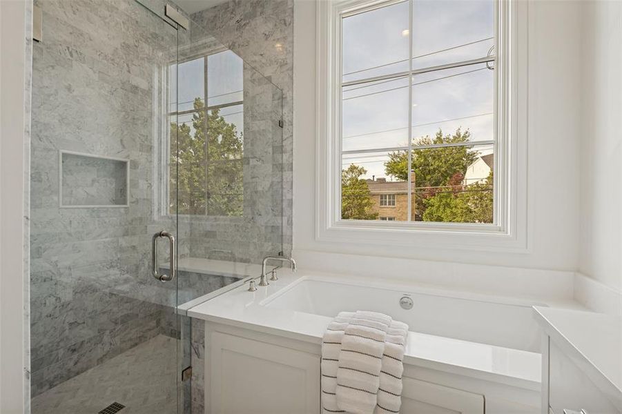 Exquisite primary bathroom featuring a separate shower and tub, premium marble finishes, and designer detail. Exquisite primary bathroom featuring a separate shower and tub, premium marble finishes, and designer detail.