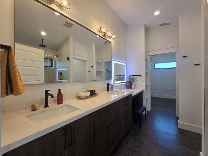 Clean lines and smooth stone countertops define this elegant contemporary double vanity space.