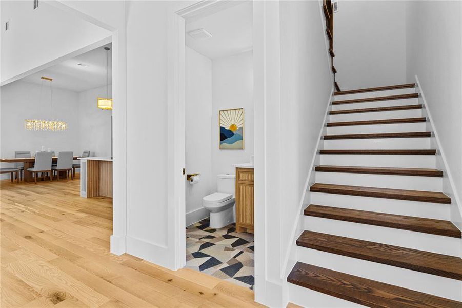 Staircase with wood finished floors and baseboards. Half Bathroom on the 1st floor Staircase with wood finished floors and baseboards. Half Bathroom on the 1st floor