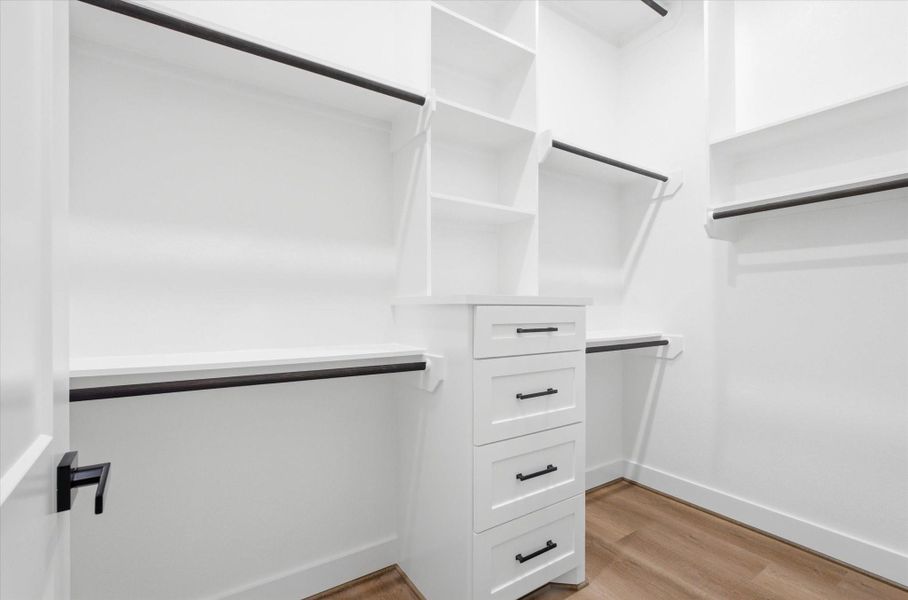 Enjoy a generous walk-in closet in the primary bedroom, thoughtfully designed with custom shelving and built-in drawers. Enjoy a generous walk-in closet in the primary bedroom, thoughtfully designed with custom shelving and built-in drawers.