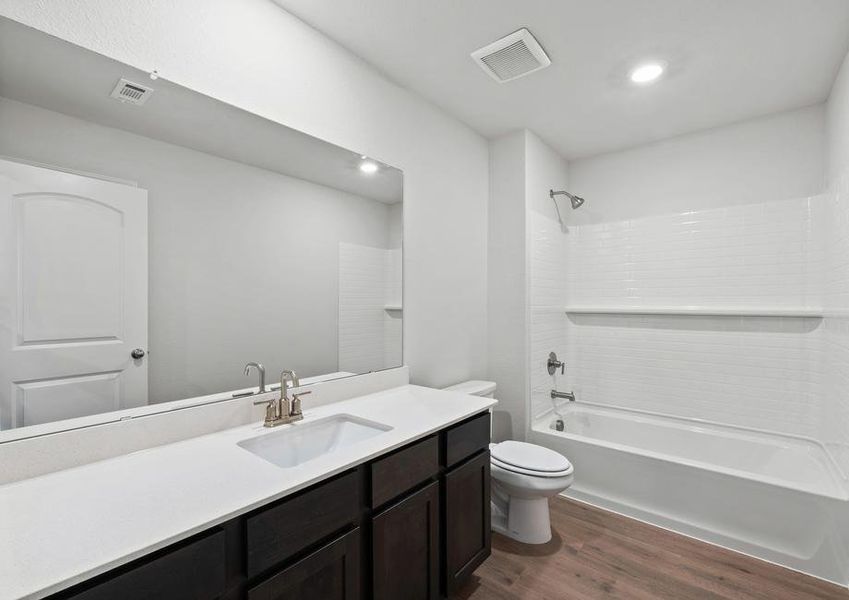 The secondary bathroom of the Juniper plan has a large vanity space and shower-tub combo.