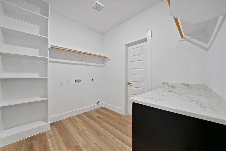 Washroom featuring light wood-style floors, hookup for a washing machine, and electric dryer hookup