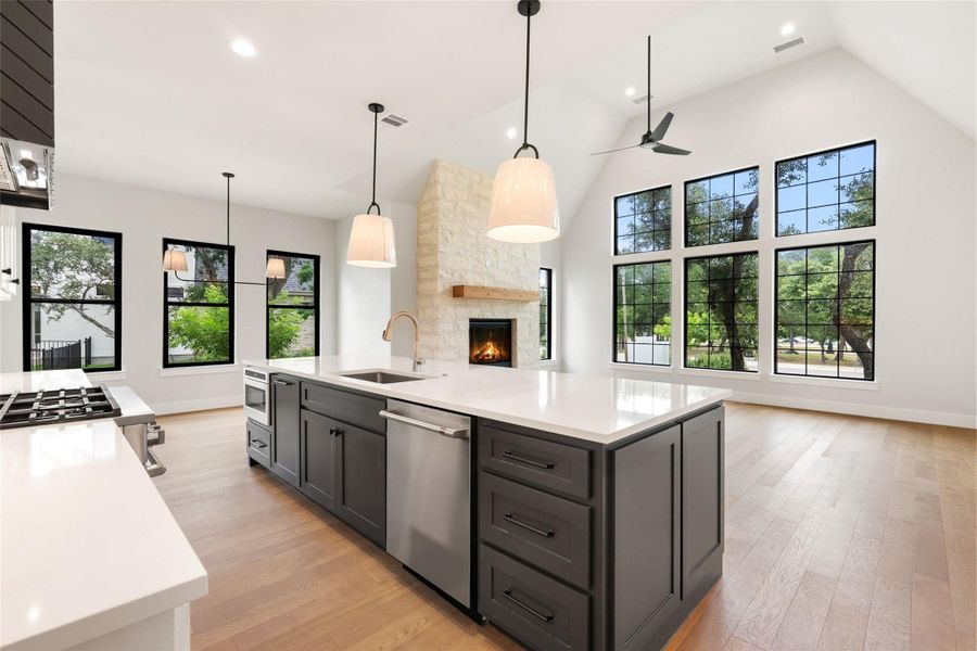 Culinary excellence meets cozy charm in this well-lit kitchen, featuring a central island and a captivating stone fireplace.