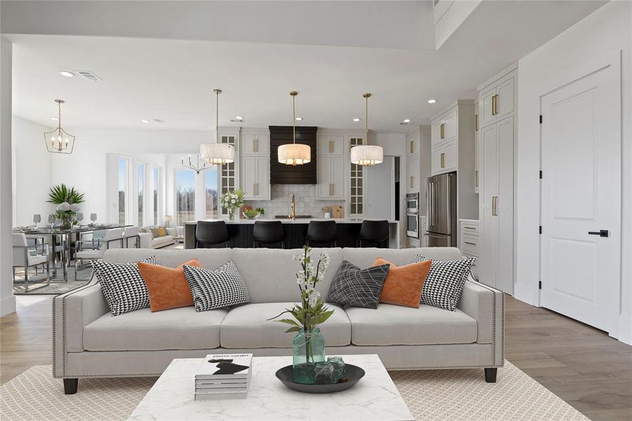 Living area featuring wood finished floors, an inviting chandelier, visible vents, and recessed lighting Living area featuring wood finished floors, an inviting chandelier, visible vents, and recessed lighting