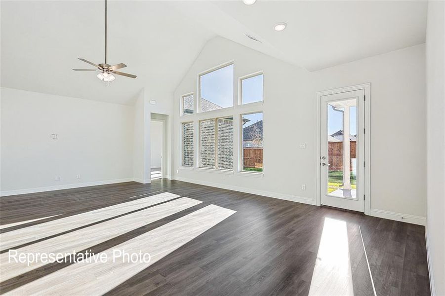 Unfurnished living room featuring ceiling fan, high vaulted ceiling, and dark hardwood / wood-style floors