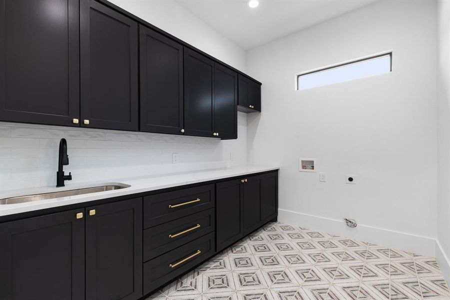 Washroom with cabinets, washer hookup, hookup for an electric dryer, and sink