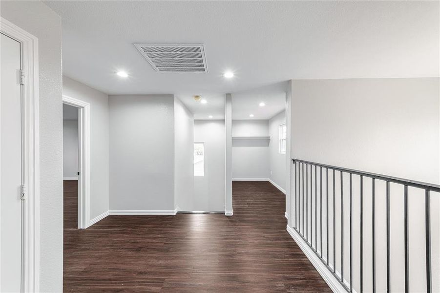 Hallway with dark wood-style flooring and recessed lighting