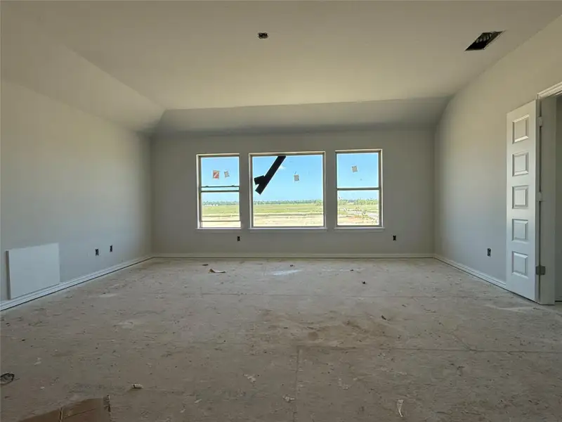 Empty room featuring vaulted ceiling and baseboards Empty room featuring vaulted ceiling and baseboards