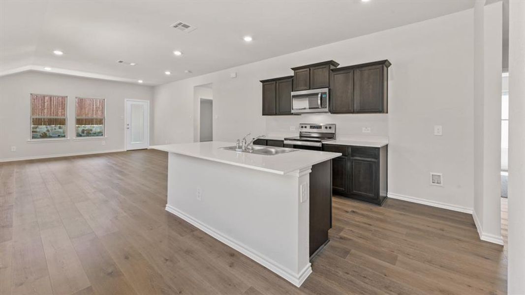 Open concept living area with wood-finish flooring