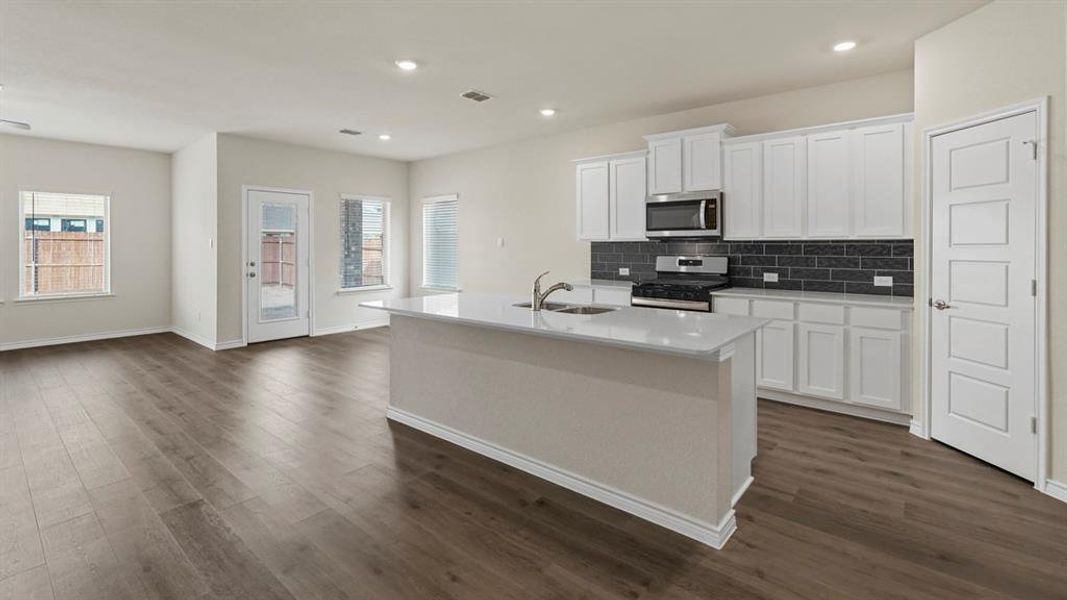 Kitchen featuring white cabinetry, an island with sink, appliances with stainless steel finishes, tasteful backsplash, and recessed lighting Kitchen featuring white cabinetry, an island with sink, appliances with stainless steel finishes, tasteful backsplash, and recessed lighting