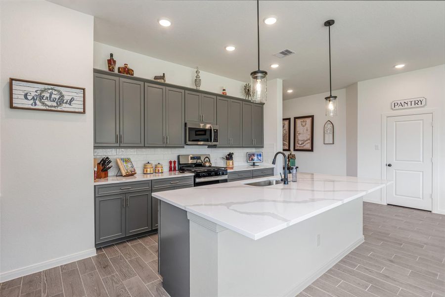 Another view of this elegant kitchen spacious featuring the white quartz island perfect for entertaining.