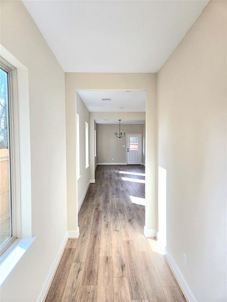 Hallway leading to open concept living/kitchen area