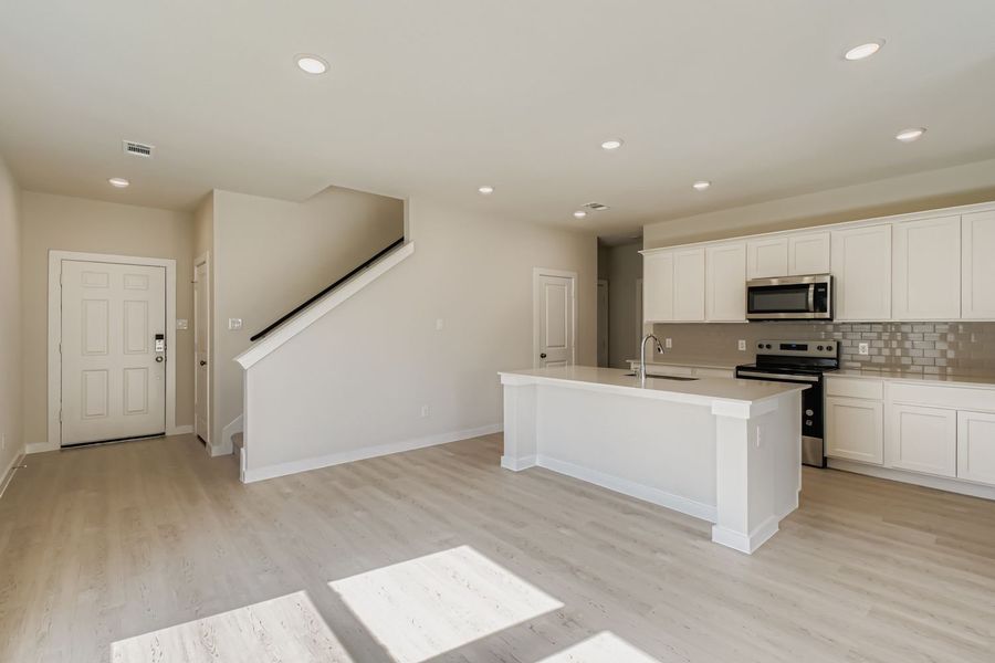 A kitchen with white cabinets.