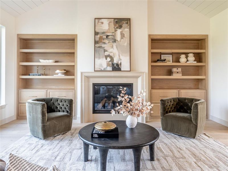 Sitting room with vaulted ceiling, a glass covered fireplace, and wooden ceiling