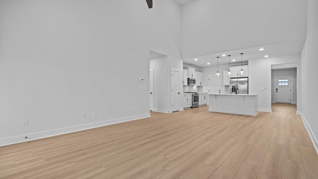 Vibrant family room with high-impact two-story ceilings and thoughtful layout for entertaining