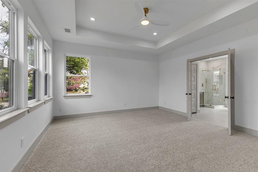 Unfurnished room featuring light colored carpet, recessed lighting, ceiling fan, and a raised ceiling Unfurnished room featuring light colored carpet, recessed lighting, ceiling fan, and a raised ceiling