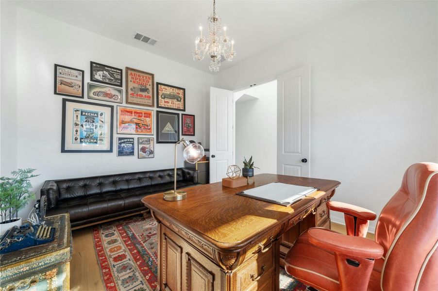 Double doors to the left of the front entry open into this sophisticated home office with tall ceilings and front yard views.