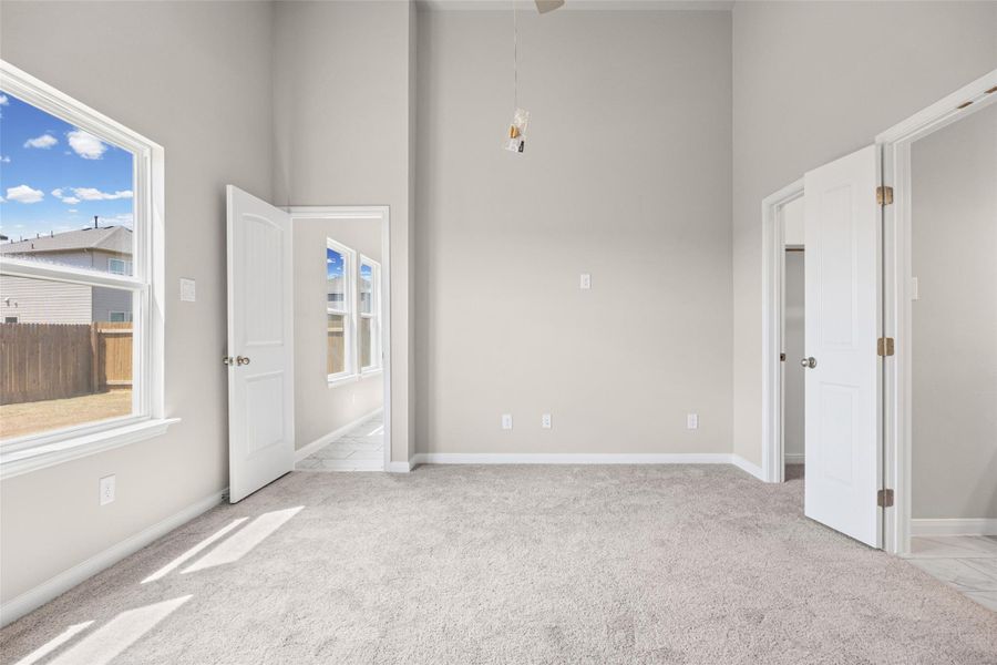 Towering ceilings and plush carpeting define this versatile secondary bedroom space. Towering ceilings and plush carpeting define this versatile secondary bedroom space.