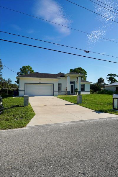 Front exterior of a new home in , Lehigh Acres, FL, highlighting curb appeal (Image 31).