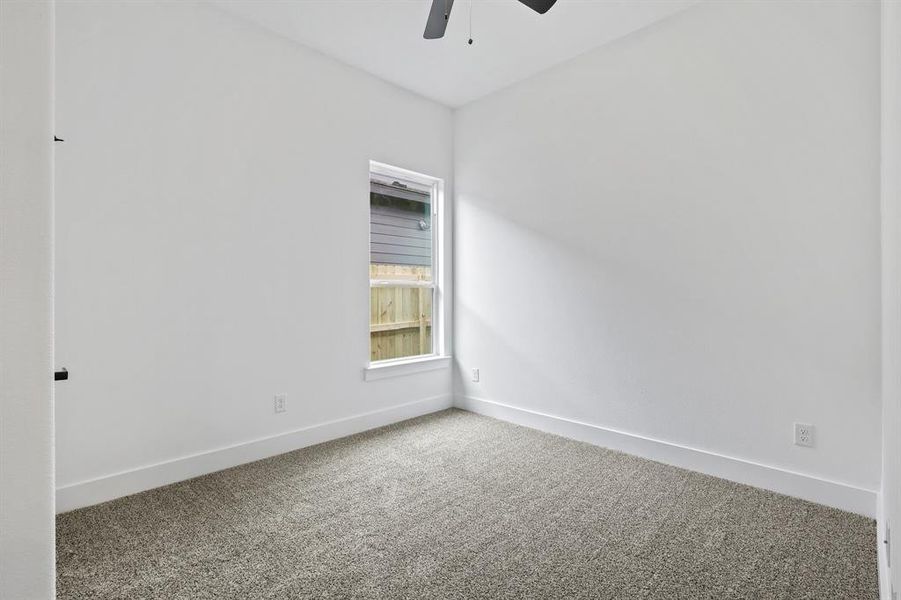 Carpeted spare room featuring ceiling fan