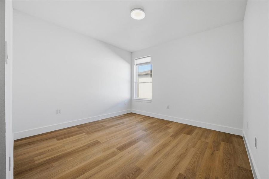 Secondary Bedroom features flush-mount lighting. Window provides natural light throughout the room. Vinyl flooring extends throughout.