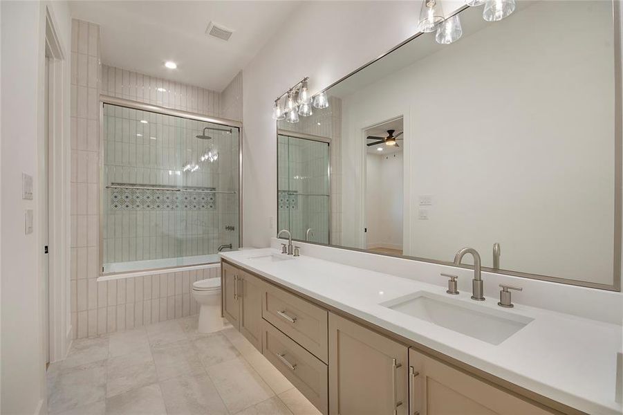 Full bath with double vanity, tiled shower / bath combo, light tile patterned floors, ceiling fan, and recessed lighting