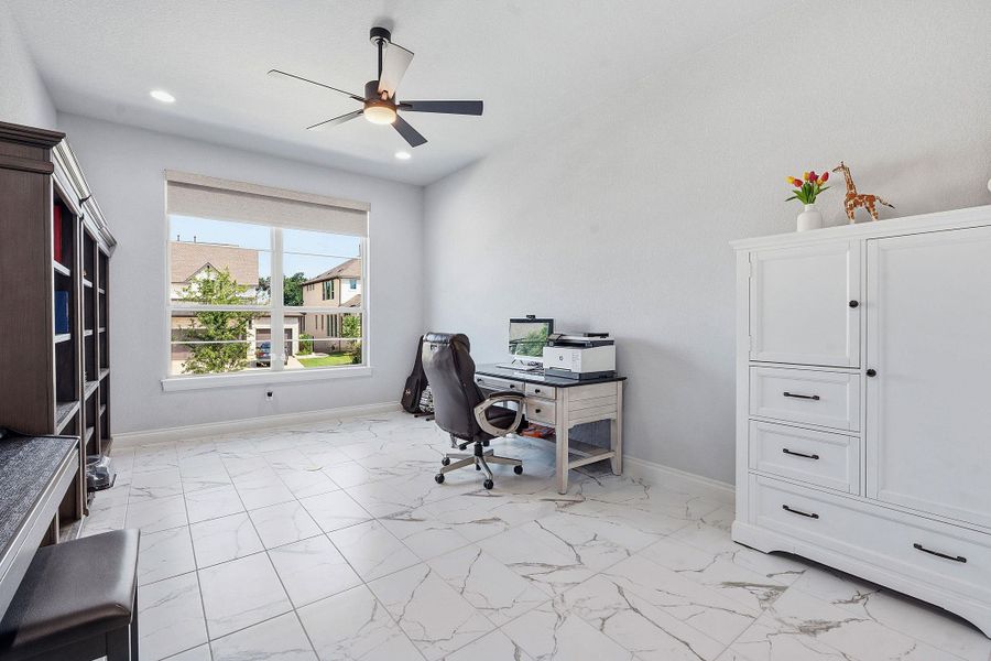 A versatile home office space features ample natural light, pristine tile flooring, and overhead illumination. A versatile home office space features ample natural light, pristine tile flooring, and overhead illumination.