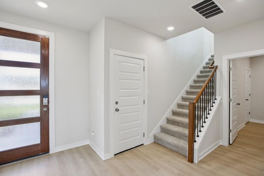 Entryway with stairway, recessed lighting, and light wood finished floors