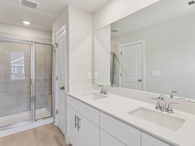 The primary bathroom boasts a dual-sink vanity and modern walk-in shower. The primary bathroom boasts a dual-sink vanity and modern walk-in shower.